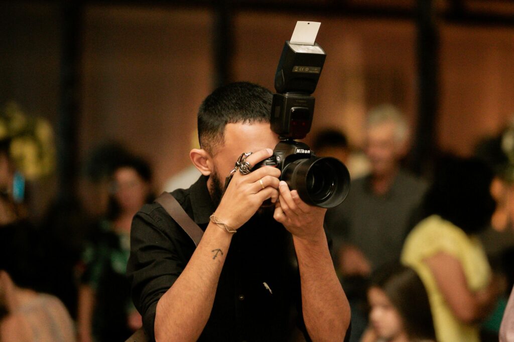 A photographer captures moments at an indoor event in Alpinópolis, Brazil.